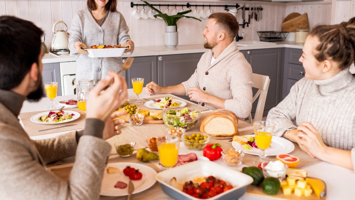 Group of friends enjoying a vibrant meal indoors, sharing laughter and good food.